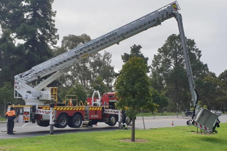 A fire truck is being serviced, it is red.