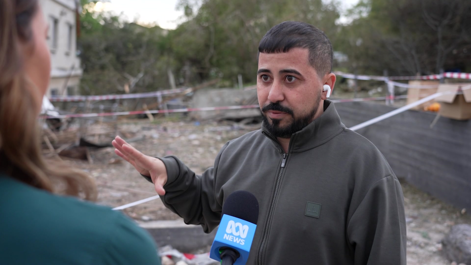 Man speaking to a journalist.