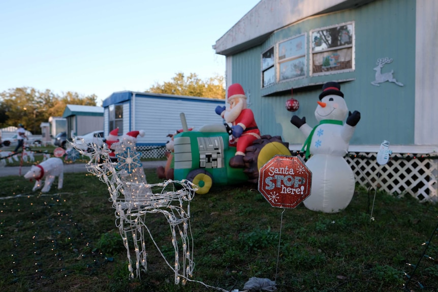 Christmas decorations adorn a lawn in front of a trailer in a US park.