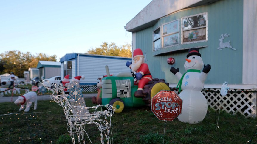 Christmas decorations adorn a lawn in front of a trailer in a US park.