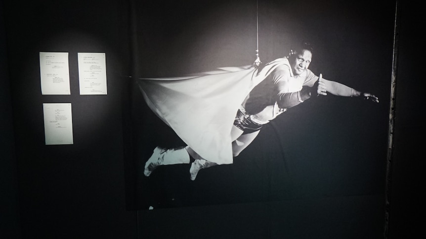 a black and white image of an aboriginal superman flying