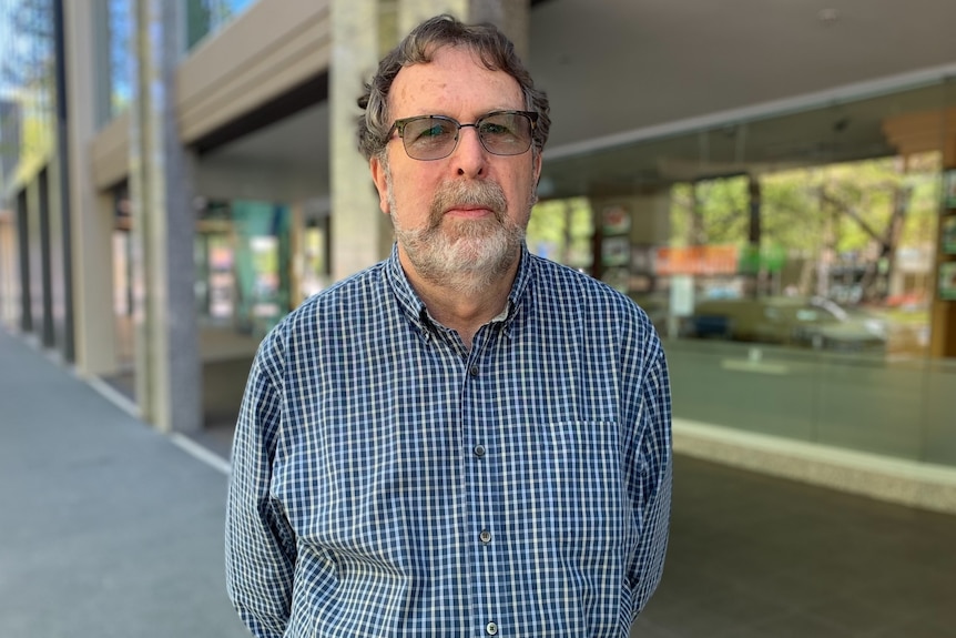 Man wearing glasses and checked shirt. 