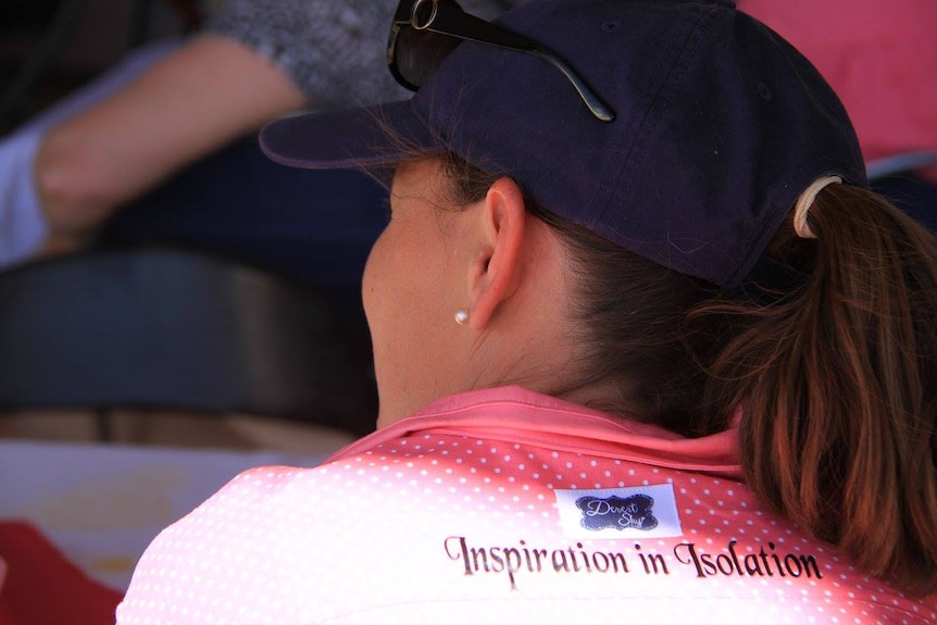 Woman wearing a shirt that says 'Inspiration in isolation'.