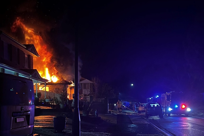 Flames rising into the sky above a house