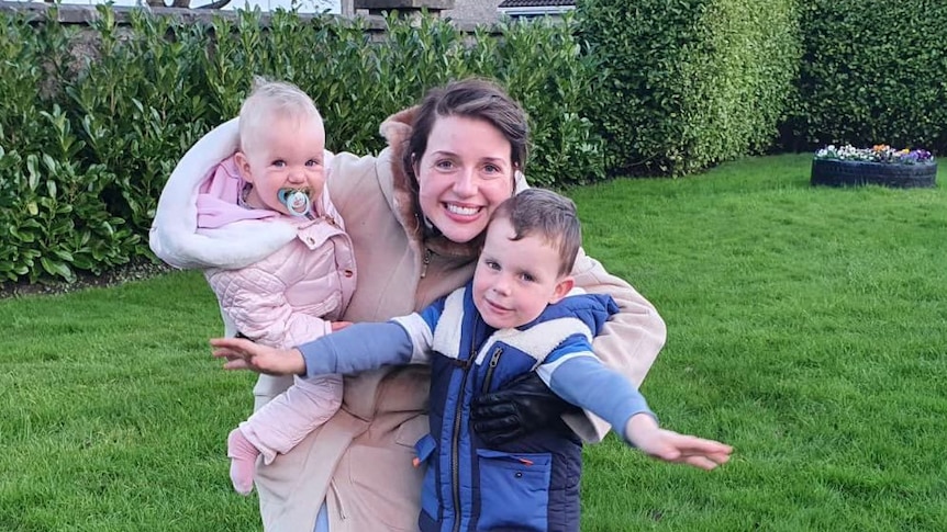 Anna Davey in a backyard with her two children.