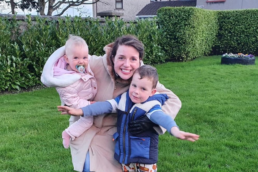 Anna Davey in a backyard with her two children.