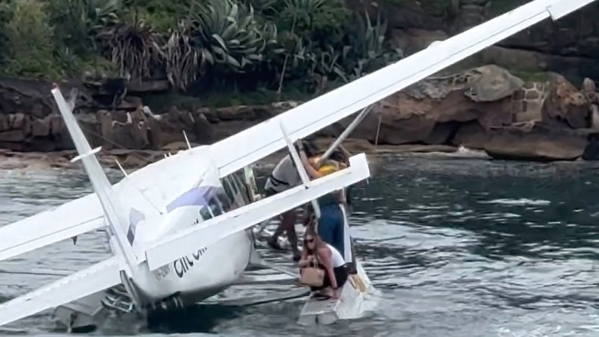 People getting off a seaplane in the ocean