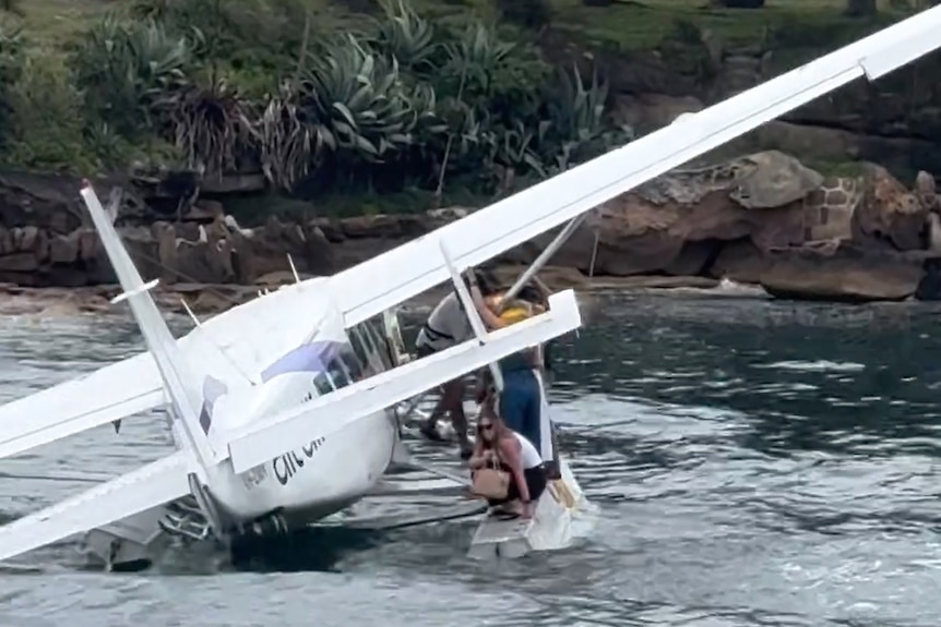 People getting off a seaplane in the ocean