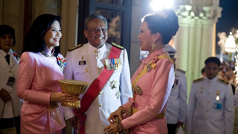 Princess Ubolratana in a royal outfit is greeted by two others in a similar outfit at the Royal Thai Government House