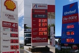 Three different petrol station signs with prices on the board 