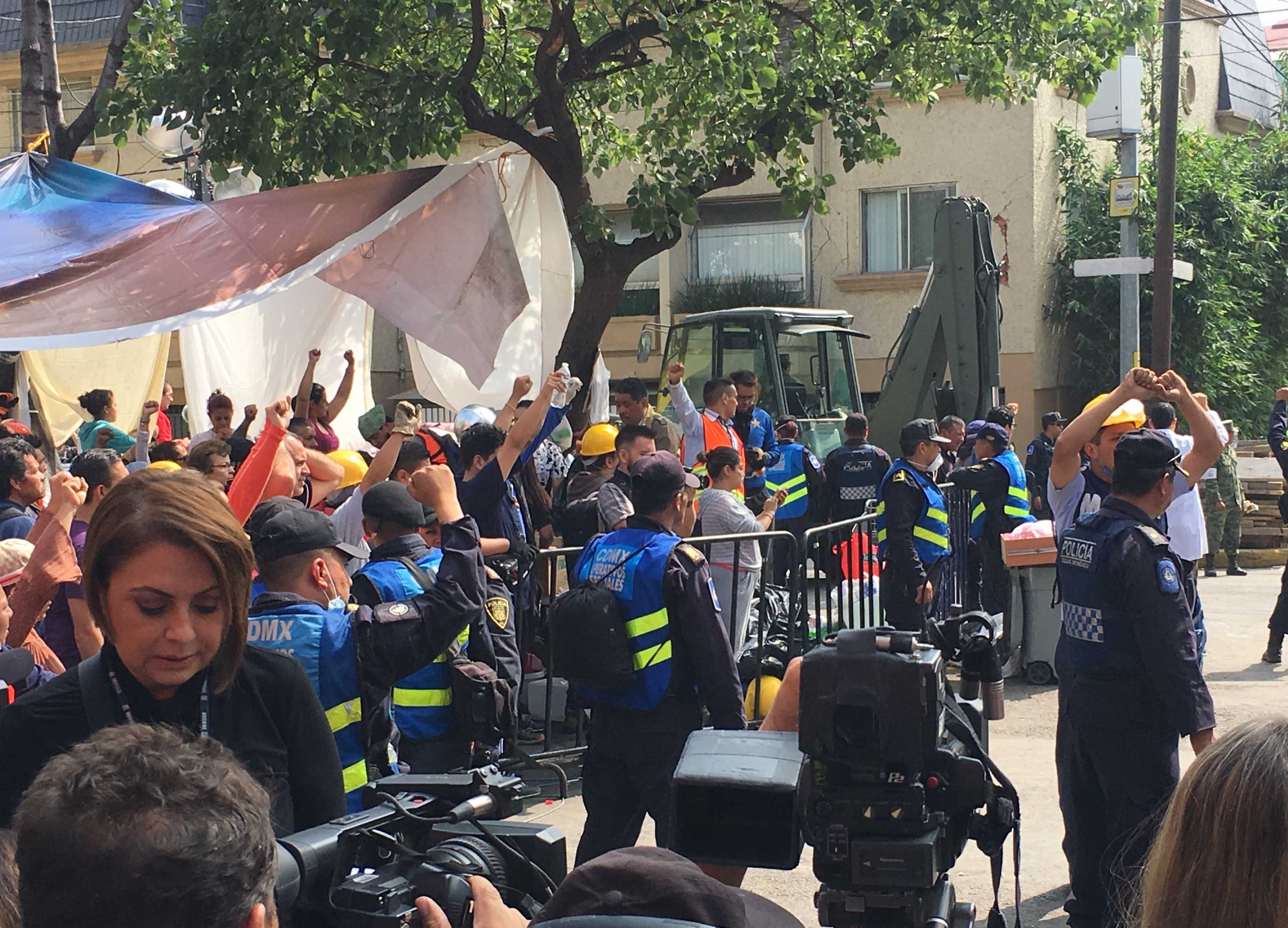 People raise their fists in the air for silence during the rescue efforts.