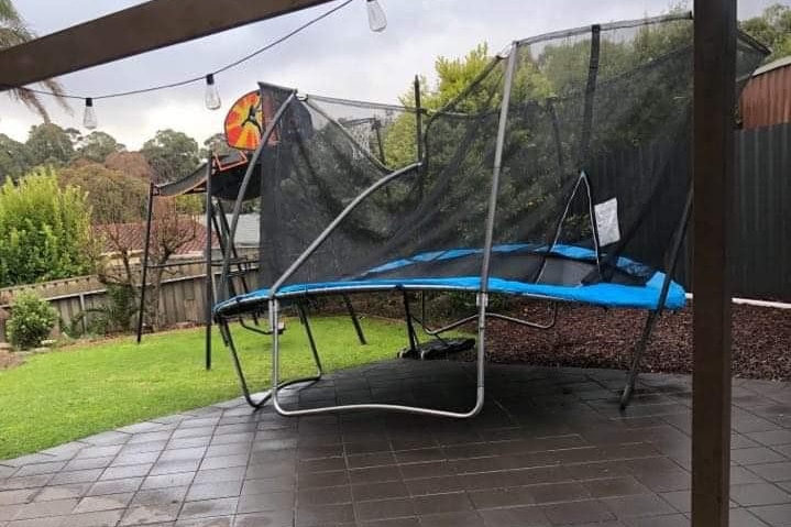 A trampoline in a back yard.