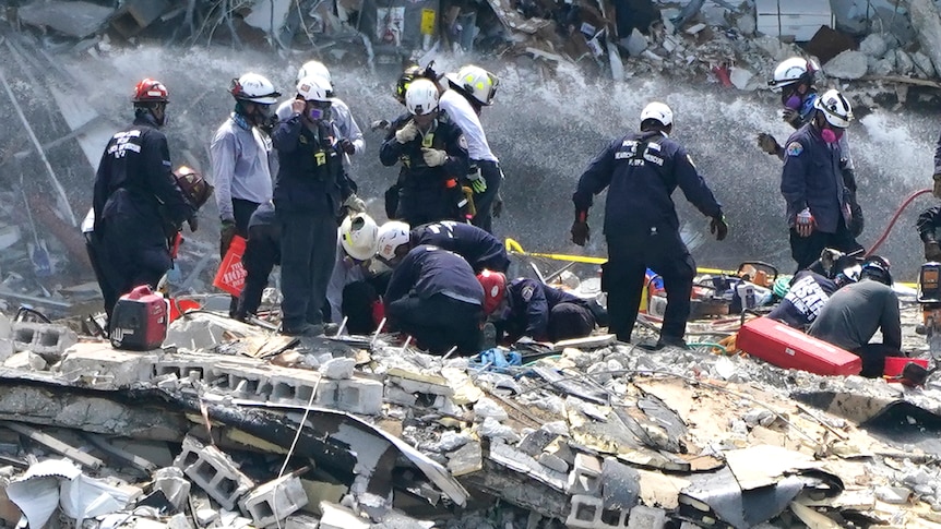 Rescue workers search the rubble of the Champlain Towers South apartment building