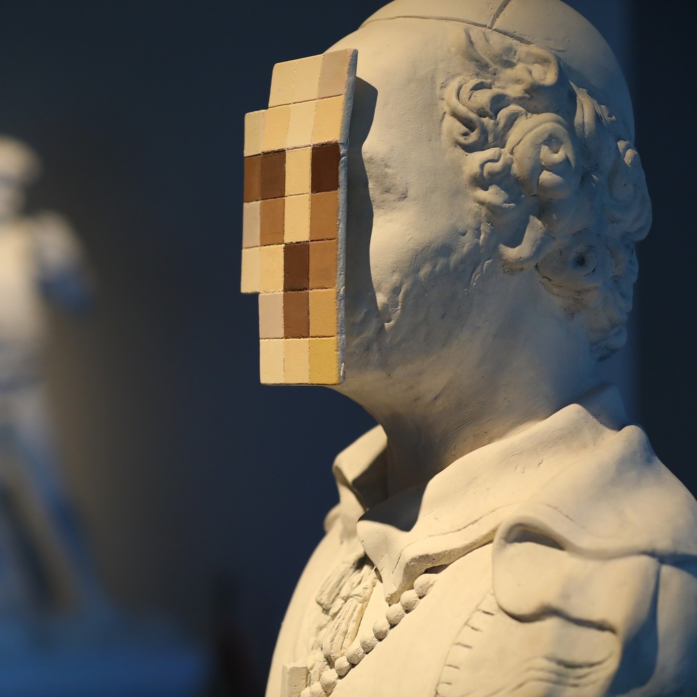 Banksy's sculpture Cardinal Sin, an 18-century stone bust of a priest with its face sawn off and replaced by pixelated tiles.