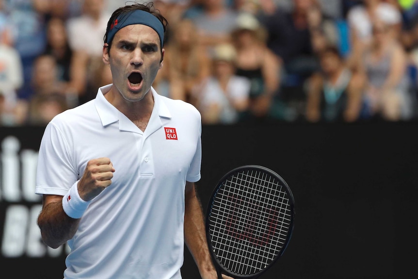 Roger Federer screams out and pumps his fist as he celebrates winning a point against Dan Evans.