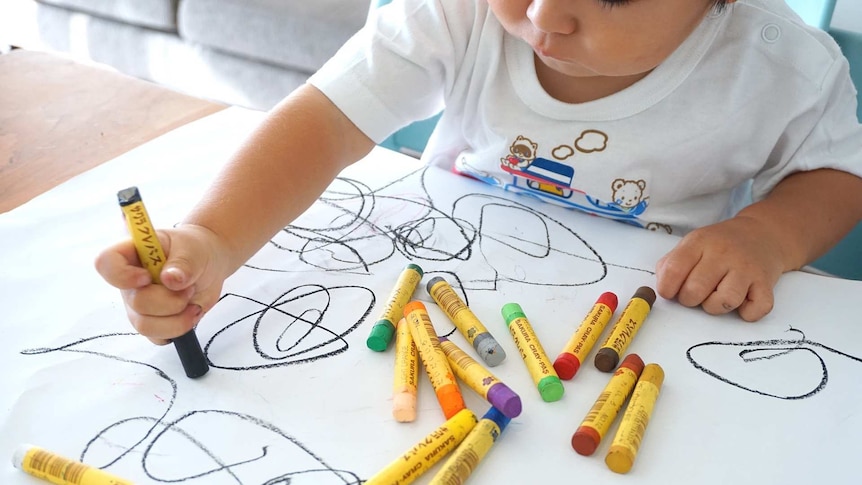 Child drawing with crayons