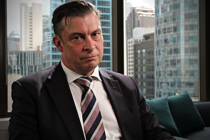 Man wearing a suit sitting in a CBD office.