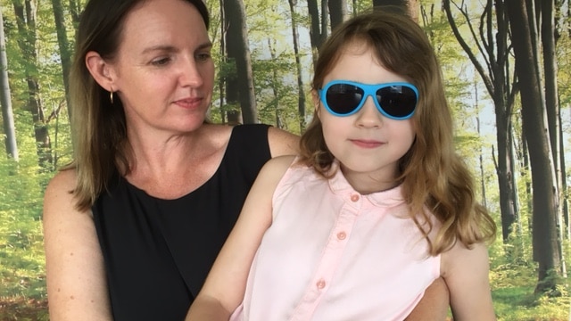 Seven year old Imogen Liddell, wearing large sunglasses, with mother Jodi.