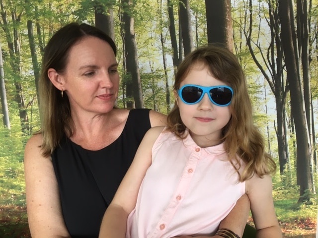 Seven year old Imogen Liddell, wearing large sunglasses, with mother Jodi.