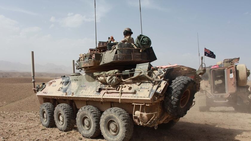 Australian troops drive an armoured-personnel carrier