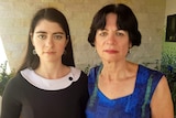 Two women stare ahead and do not smile