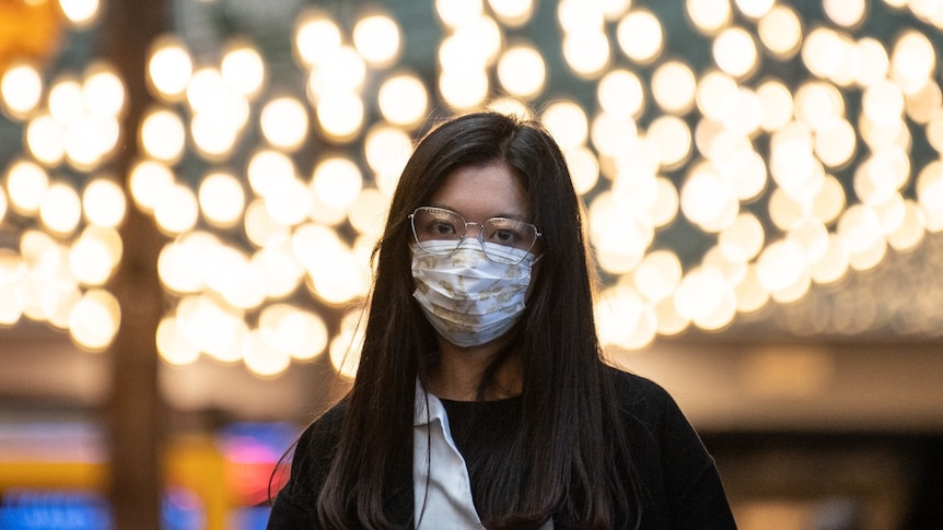 A woman wears a protective mask.