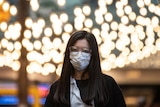 A woman wears a protective mask.