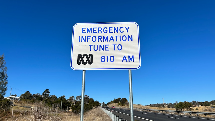 A roadside sign displaying the radio frequency for local ABC Emergency broadcasts in the Bega area. 