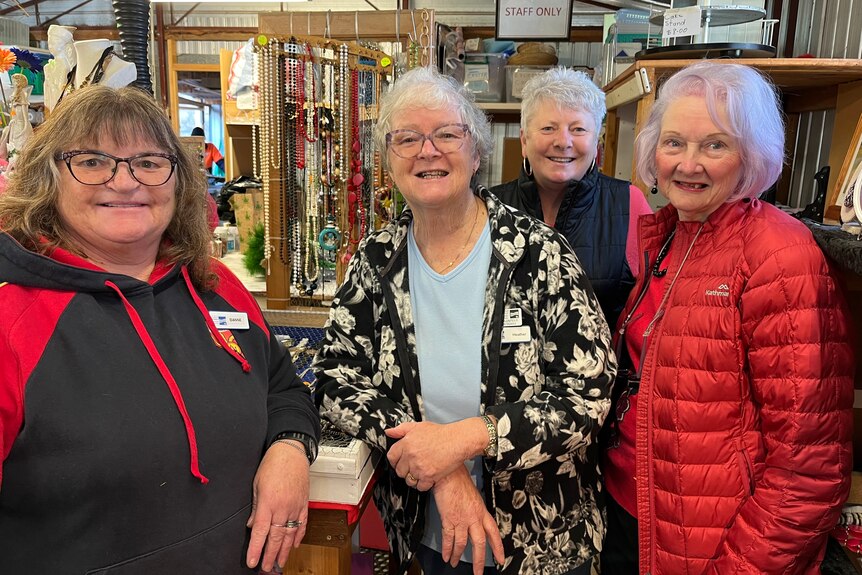 Four women standing in the op shop where they volunteer.