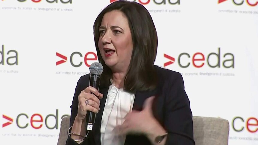 Qld Premier Annastacia Palaszczuk holding a microphone and speaking to a public forum