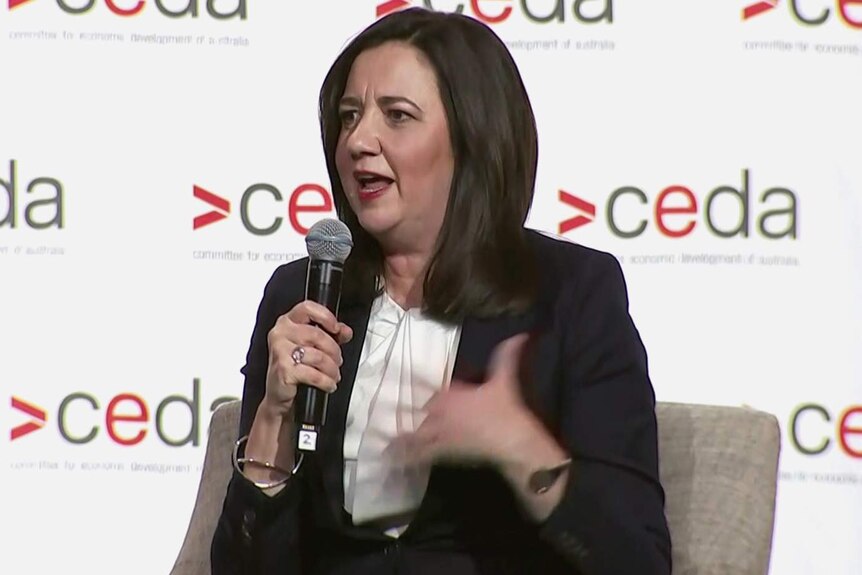Qld Premier Annastacia Palaszczuk holding a microphone and speaking to a public forum