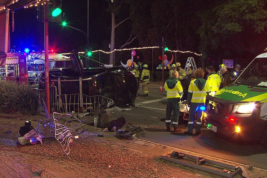 Emergency workers at the scene of a crash where a car rolled onto its side.