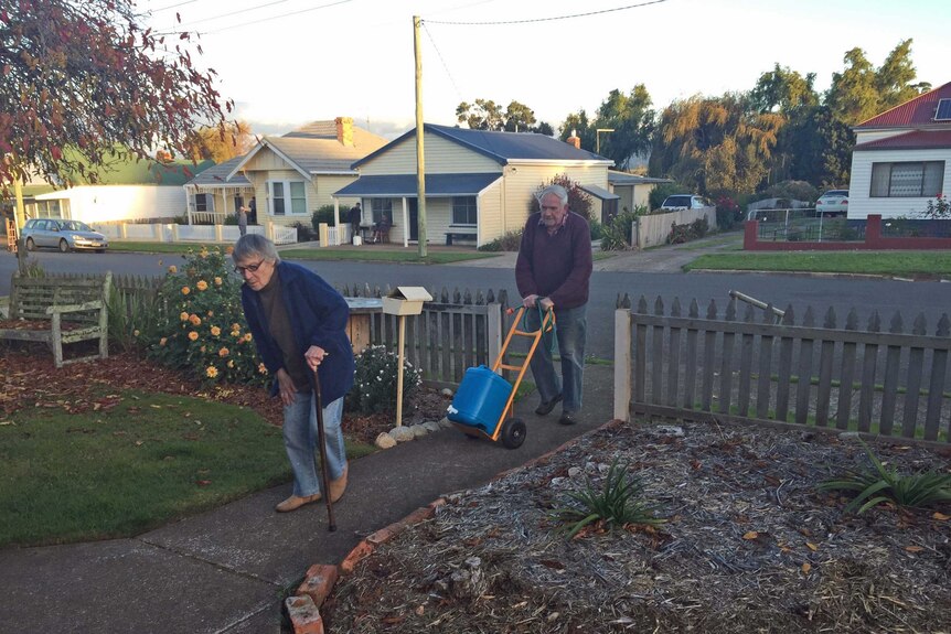 An elderly Tasmanian couple cart water to their house in Tasmania's north-east