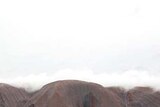 A cloud sits over Uluru
