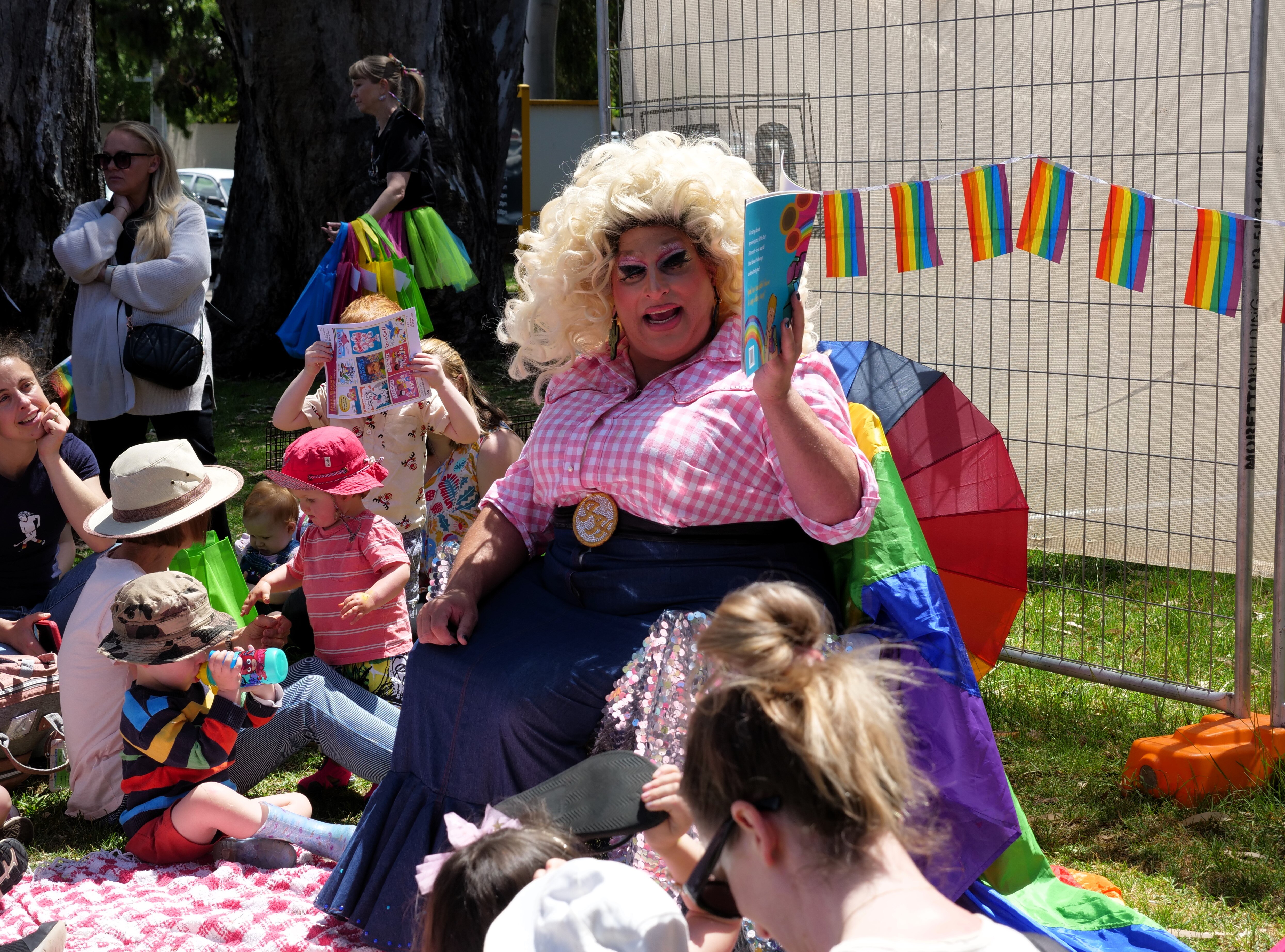 Dean Arcuri, a drag artist also known as Frock Hudson, reads a book to a group outside Shepparton Library