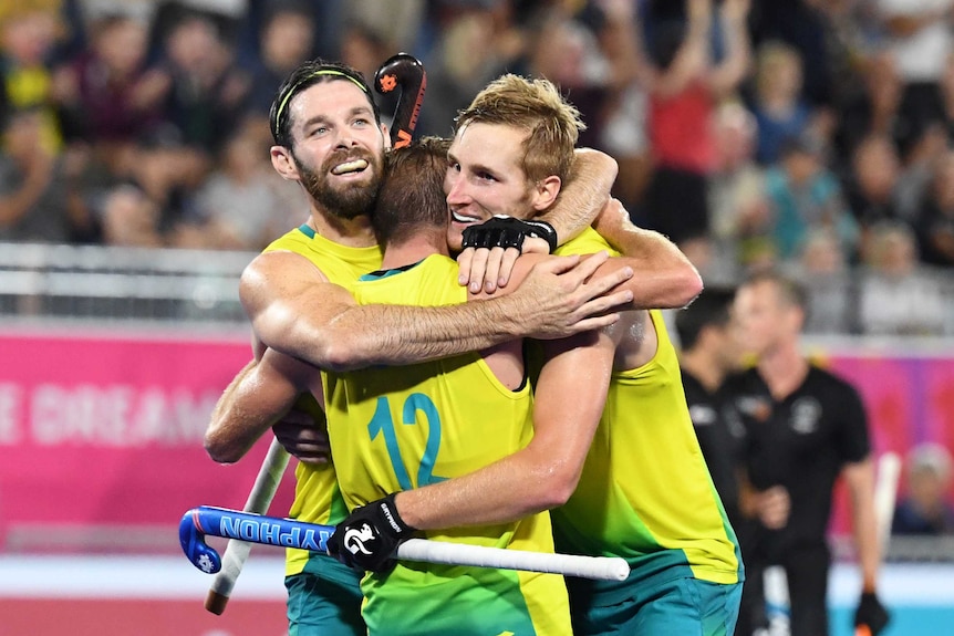 Australian men's hockey players embrace and celebrate