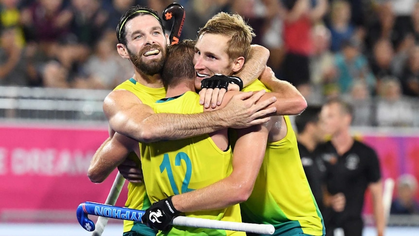 The Australian team celebrate after beating New Zealand for the men's hockey gold medal.