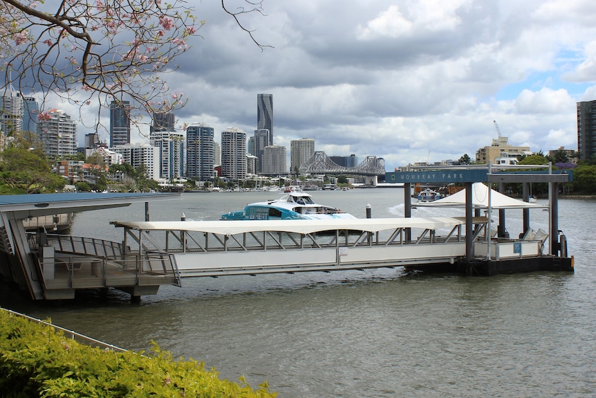 A ferry terminal with the Brisbane CBD in the background.