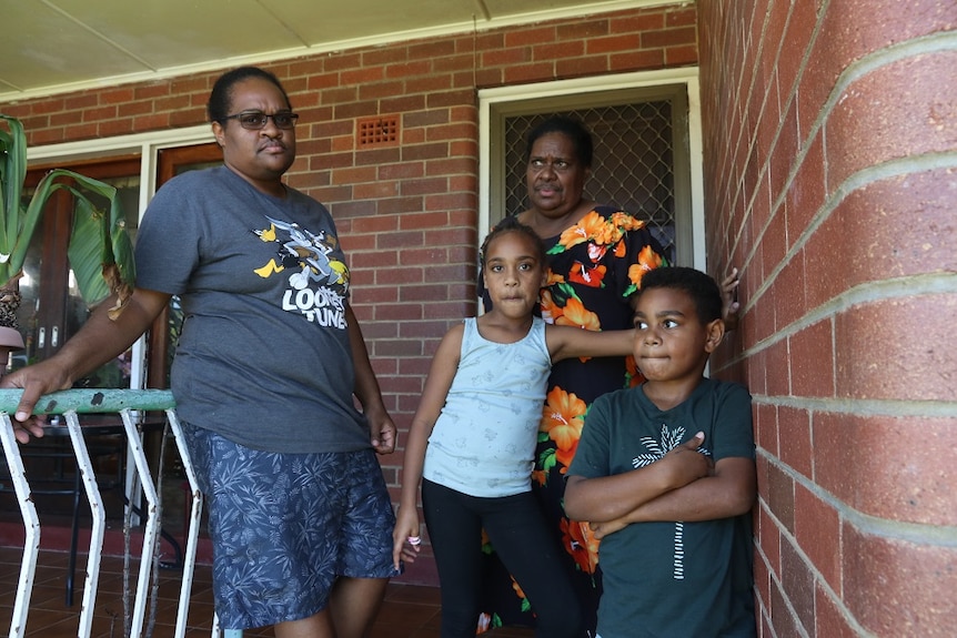 Torres Strait Island family on steps outside front of their house in Cairns.