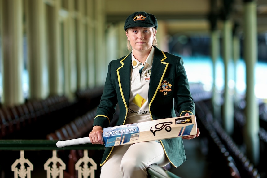 Alyssa Healy sits in the old members stand at the SCG with her captain's blazer and baggy green on