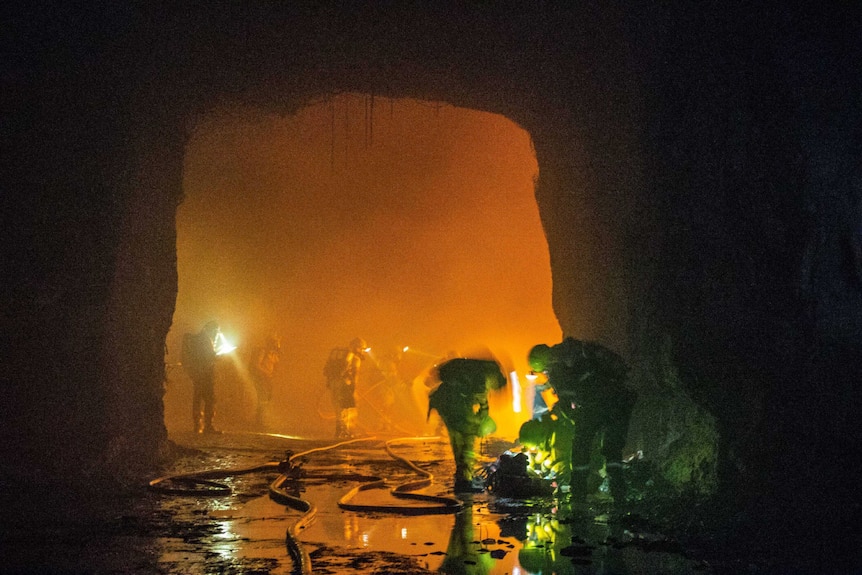 Mine workers in an underground mine during a firefighting exercise.