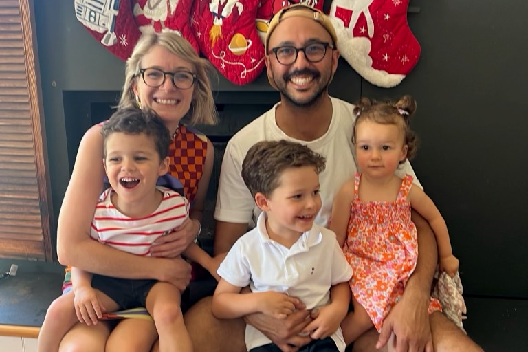  family of five in front of christmas stockings