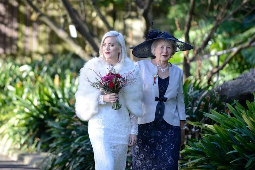 A woman in a wedding dress next to an older woman. 