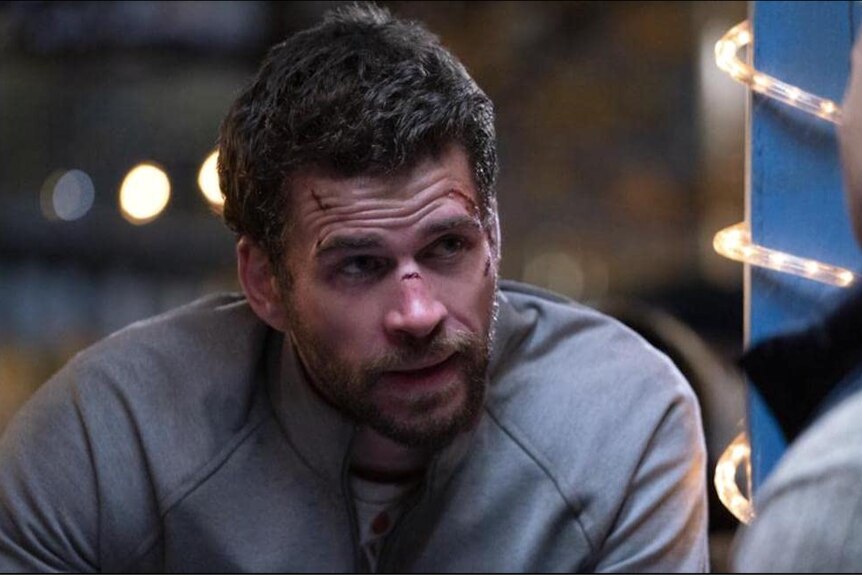 Hemsworth appears in a scene with cuts on his face