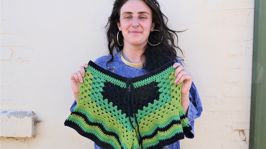 Alex Rosenblum holding one of her crochet creations.