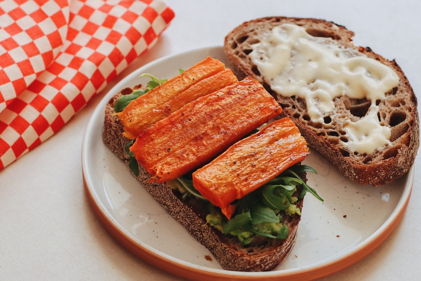 A roast carrot sandwich with rocket, avocado and mayo on sourdough bread. One way to enjoy spiced roast carrots.