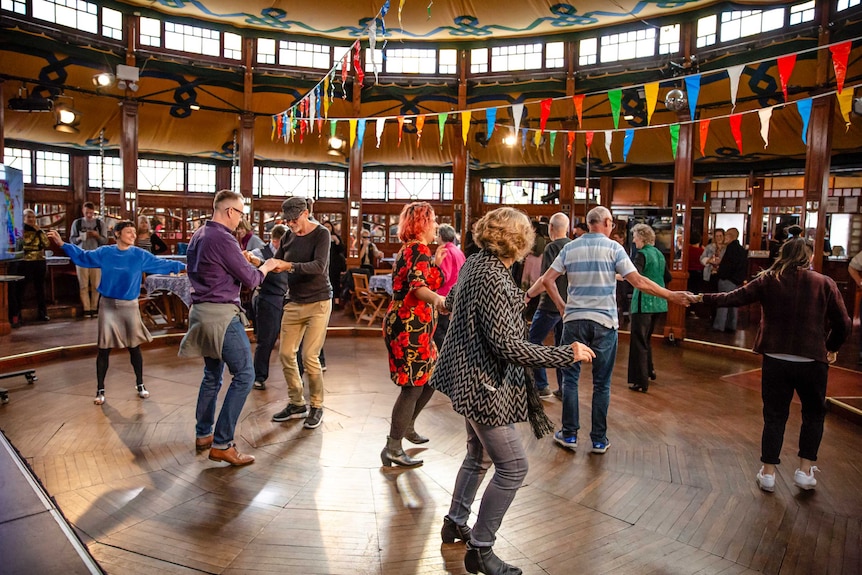 A group of people dancing in a hall