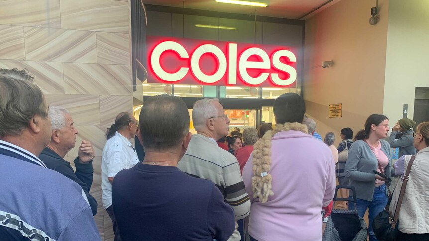A large queue outside a Coles supermarket