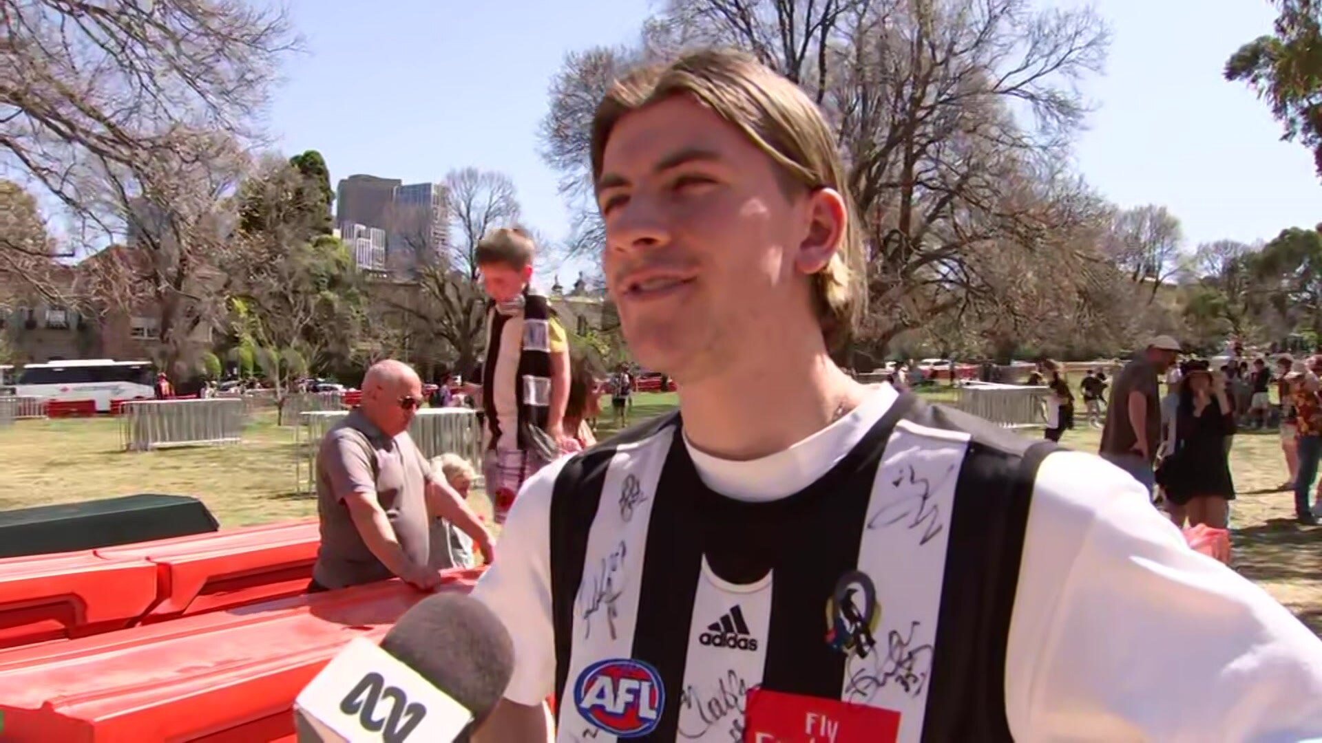 A young man wearing a Collingwood jersey over a white T-shirt.