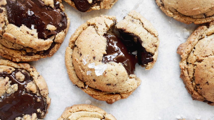 A close up of a freshly baked chocolate chip cookies with melted chocolate, illustrating our recipe.